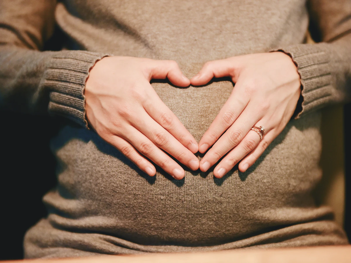 Illustrative photograph of an expectant mother holding her baby bump